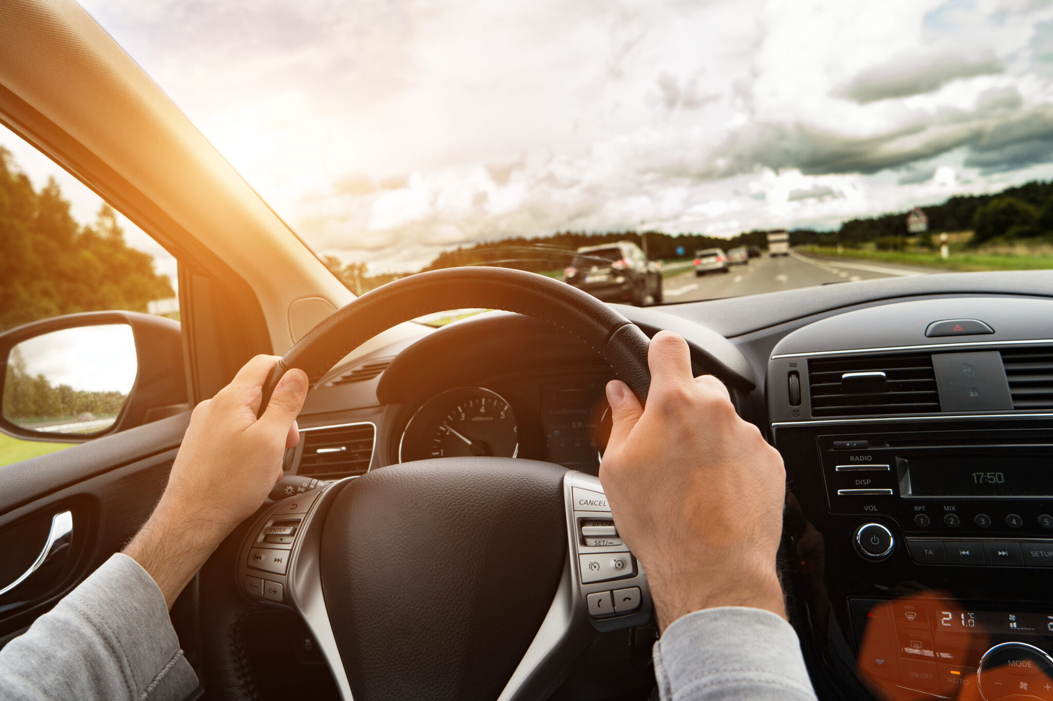 Detail of a man driving his car. Bright light effect